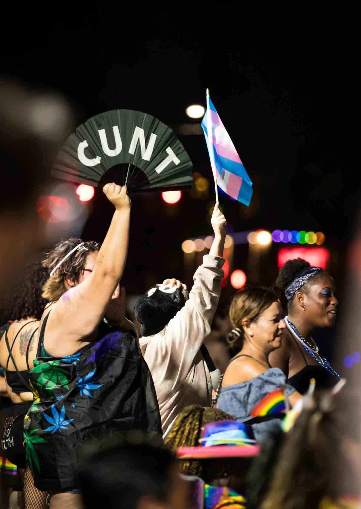 San Antonio gay pride parade photos of woman holding fan with word CUNT