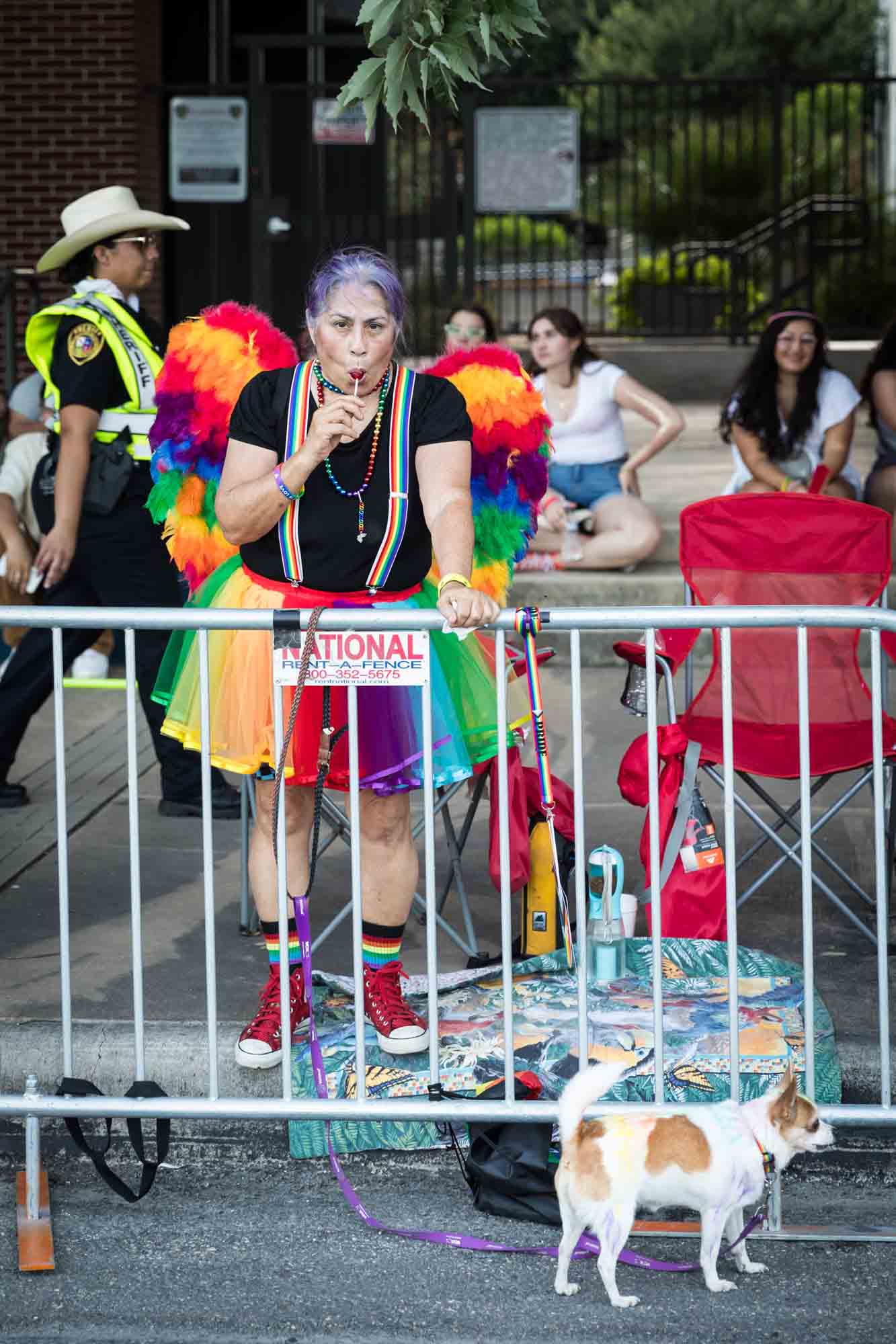 San Antonio gay pride parade photos of people leaning against metal railing waiting for parade to begin