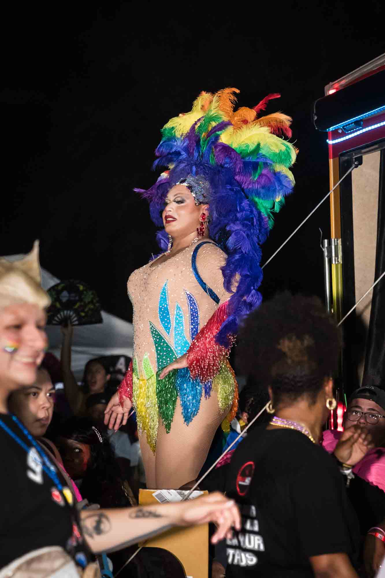 San Antonio gay pride parade photos of drag queen wearing rainbow feathered headdress