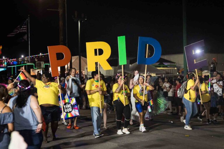 San Antonio gay pride parade photos of people holding pride letters in parade