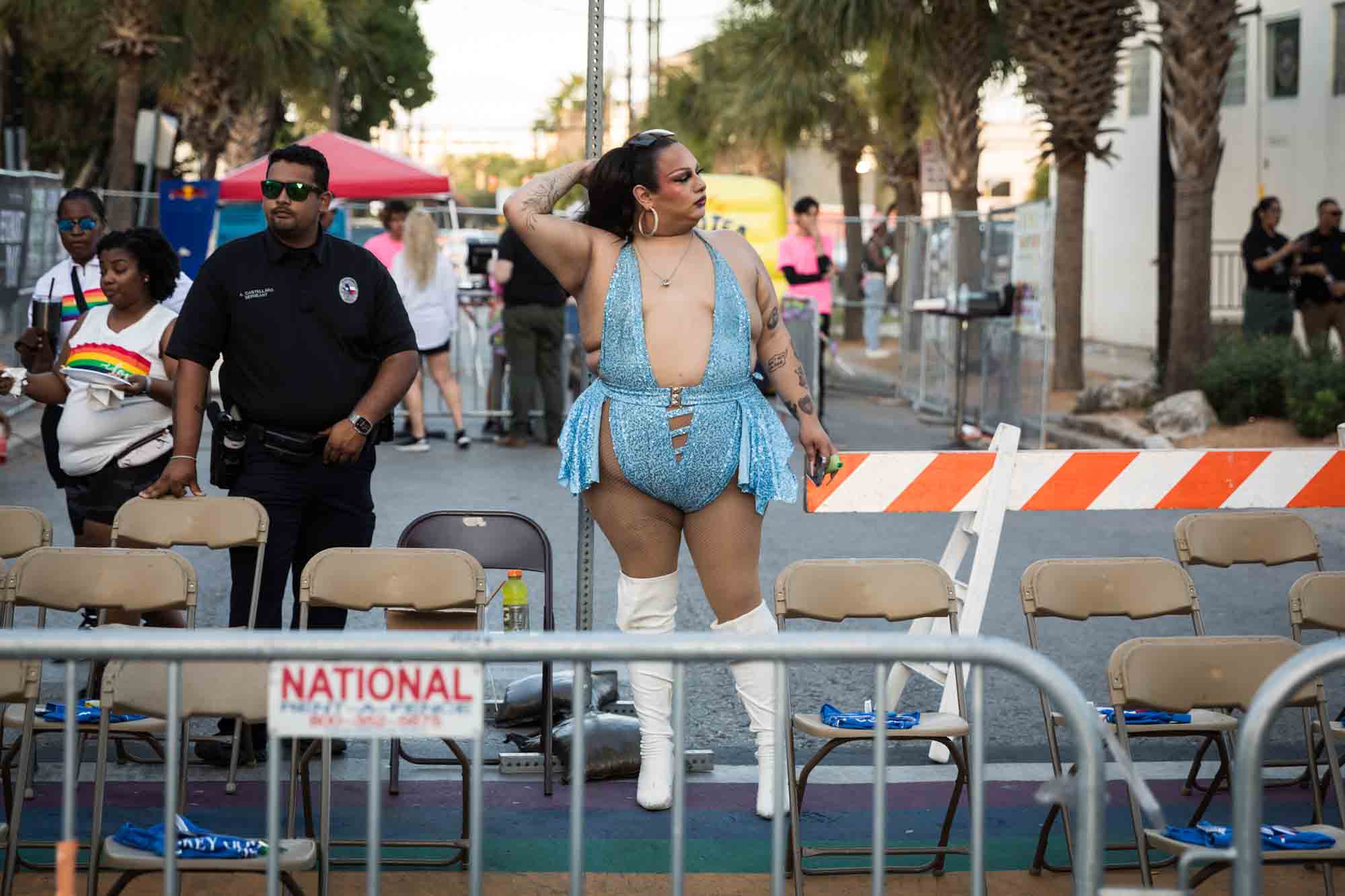 San Antonio gay pride parade photos of people leaning against metal railing waiting for parade to begin